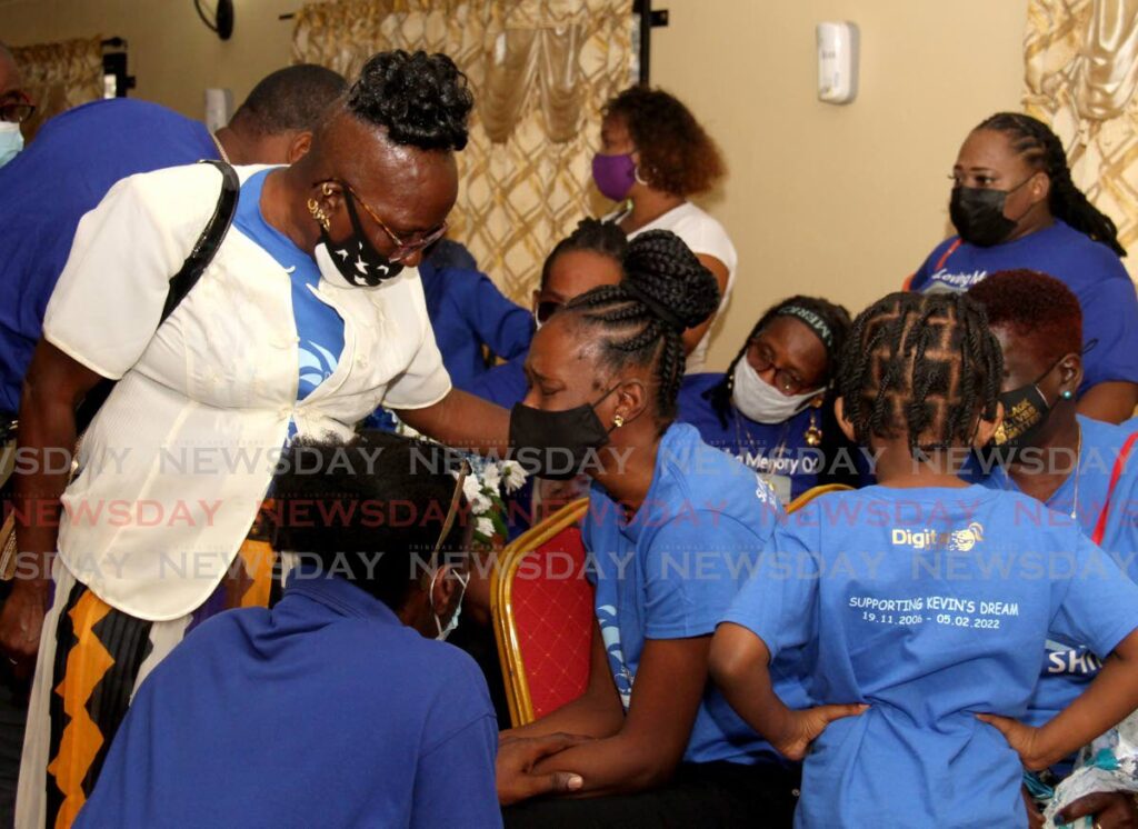 Sherma Spring, mother of murder victim Kevin Spring, 15, is consoled during his funeral at Dennie's Funeral Home in Belmont on Monday. - AYANNA KINSALE