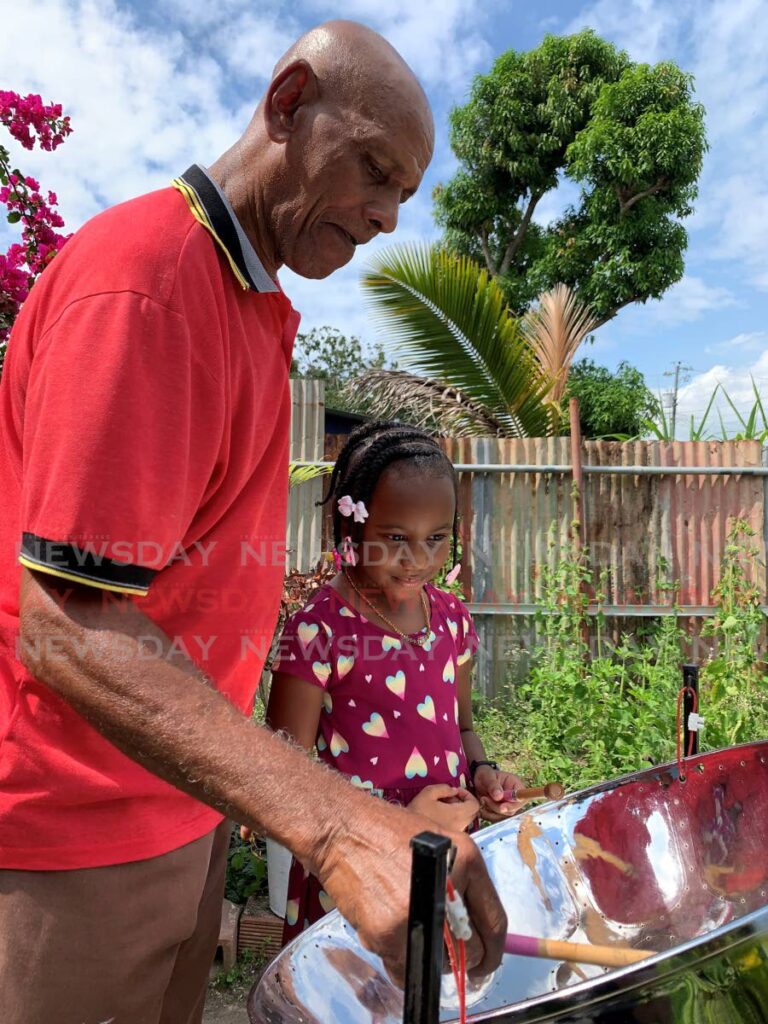 David Sylvester teaches his granddaughter Aaliyah Livingston how to play the tenor pan at their home in Basta Hall, Couva. Photo by Marvin Hamilton