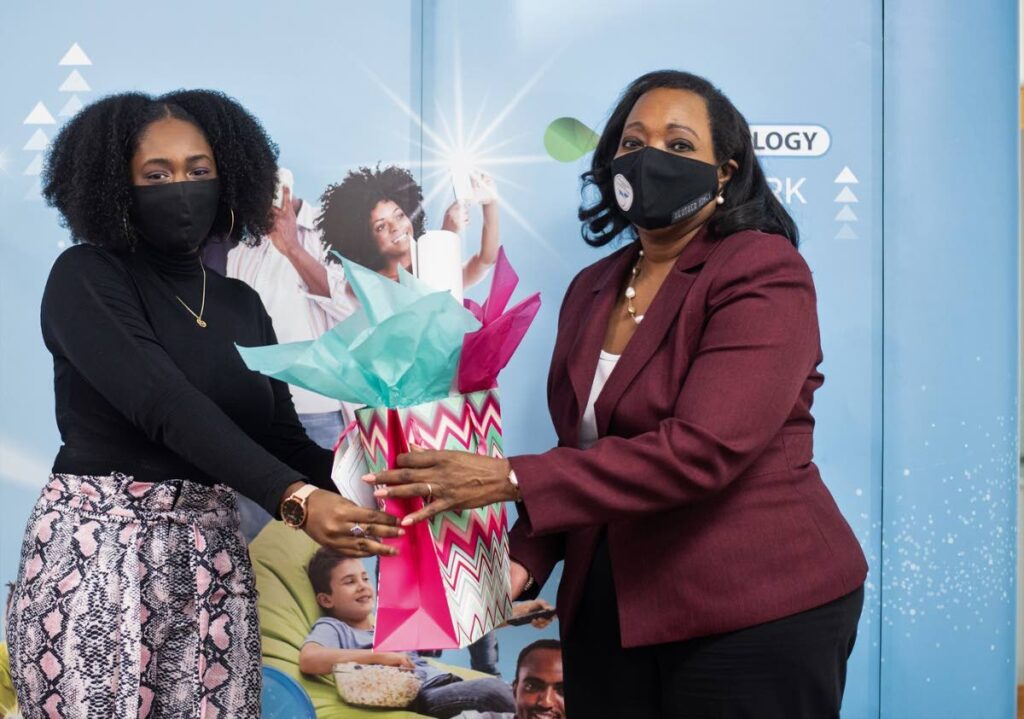 WELL DONE: Reinika Howard of Eco Works Products accepts her prize for top website from Cynthia Reddock-Downes, CEO -TATT, right, at the graduation for Tech4Girls Connecting Girls, Creating Brighter Futures workshop. PHOTO COURTESY BMOBILE - BMOBILE