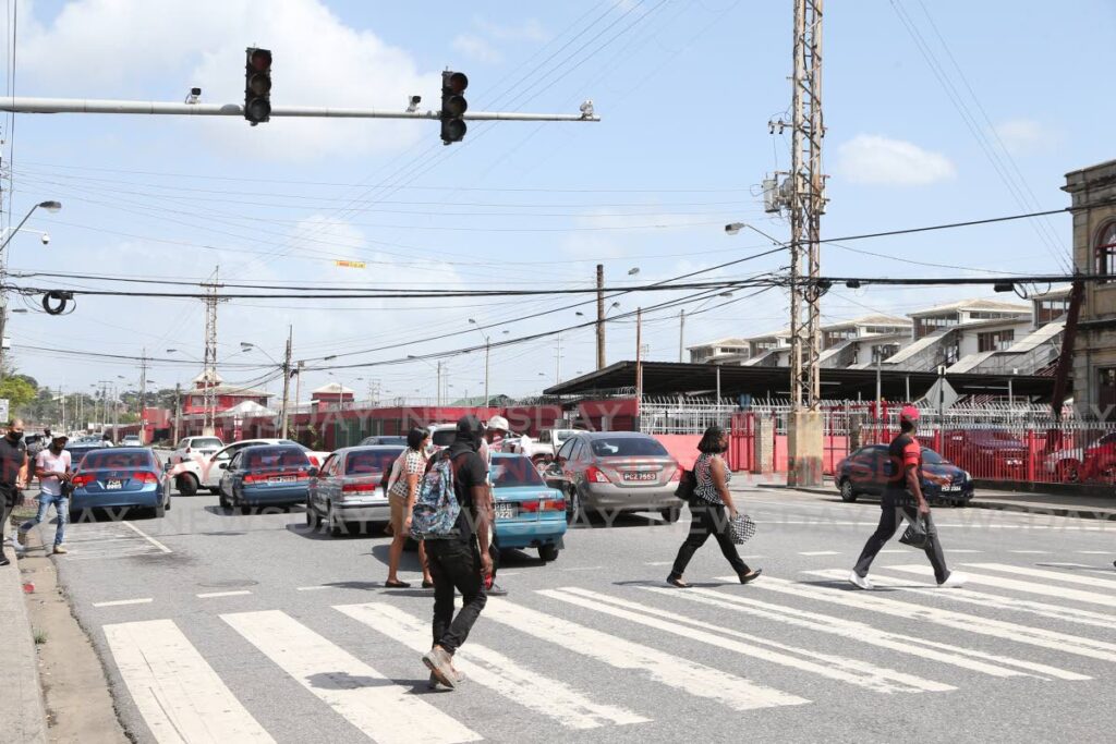 NO POWER: Traffic lights in front of City Gate were not working during the nationwide blackout causing pedestrians to maneuver between vehicles on South Quay in Port of Spain on Wednesday. PHOTO BY JEFF MAYERS - 