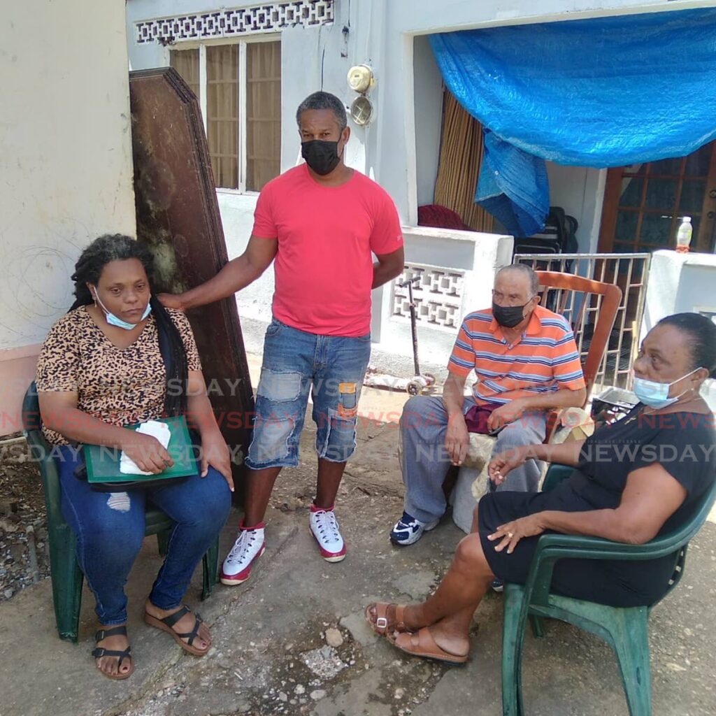 Mother of Antonio Badenoch, Philippa Ramsewak, left, step-father Andrew Baptiste, father Wilfred Badenoch and grandmother Elaine Phillip-Ramsewak console each other in the yard of their St Vincent Street, Tunapuna home, Thursday. - Photo by Shane Superville