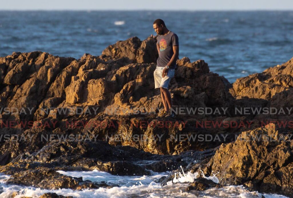 Joel London, brother of missing fisherman Lorenzo London, looks at the sea in Back Bay on Thursday afternoon after his sibling was swept off a rock by a wave earlier in the day. The search continues for his brother. - Photo by David Reid