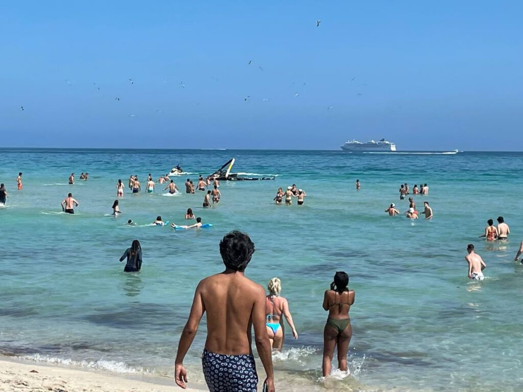 Sea bathers look on during a rescue operation at Miami Beach on Saturday after a helicopter crashed near the shore. - Photo courtesy Qia Grosvenor
