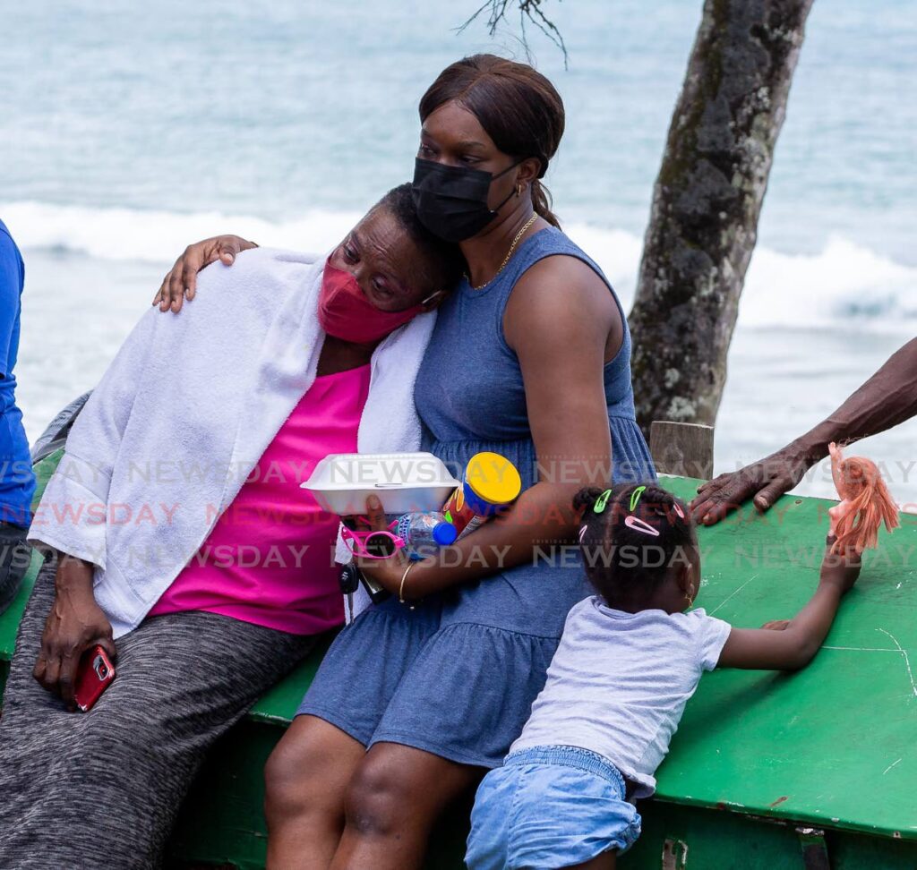 Cheryl London, left, mother of deceased Lorenzo London, is consoled by a relative at Grafton Beach, Black Rock on Sunday morning. - Photo by David Reid