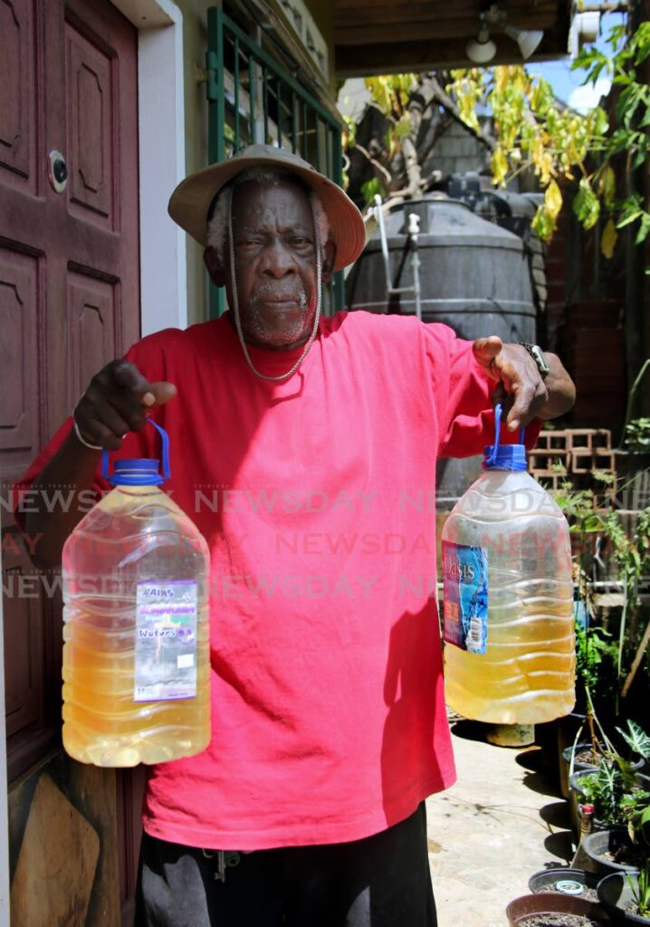 George Duncan showing the brown dirty water that he received from a truck borne supply that he paid for, at his home on Johnson Lane, Basilon Street in East Port of Spain where there has been no water in the taps of the  residents in the area for the longest while.  - SUREASH CHOLAI