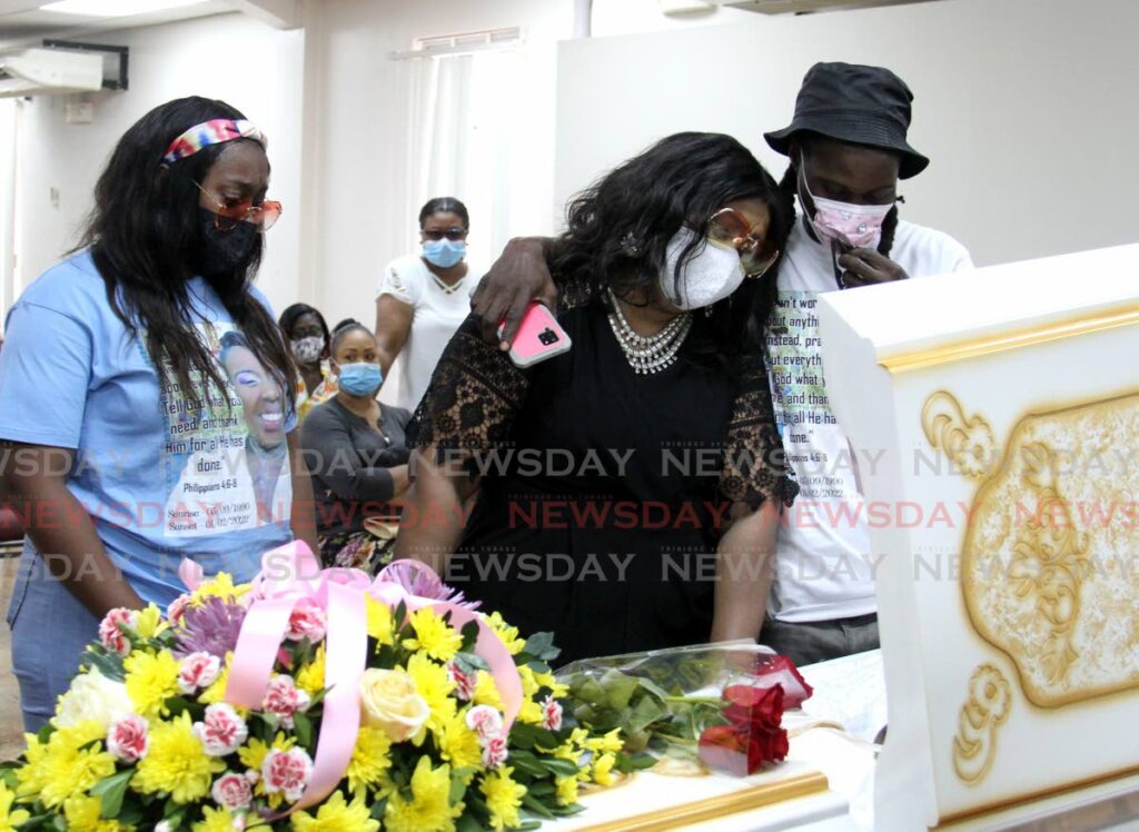 Annmarie Taylor, centre, aunt of of Crystal George is consoled by relatives as she looks at her niece during her funeral at the Covenant House of Praise in Tunapuna, Thursday. - AYANNA KINSALE