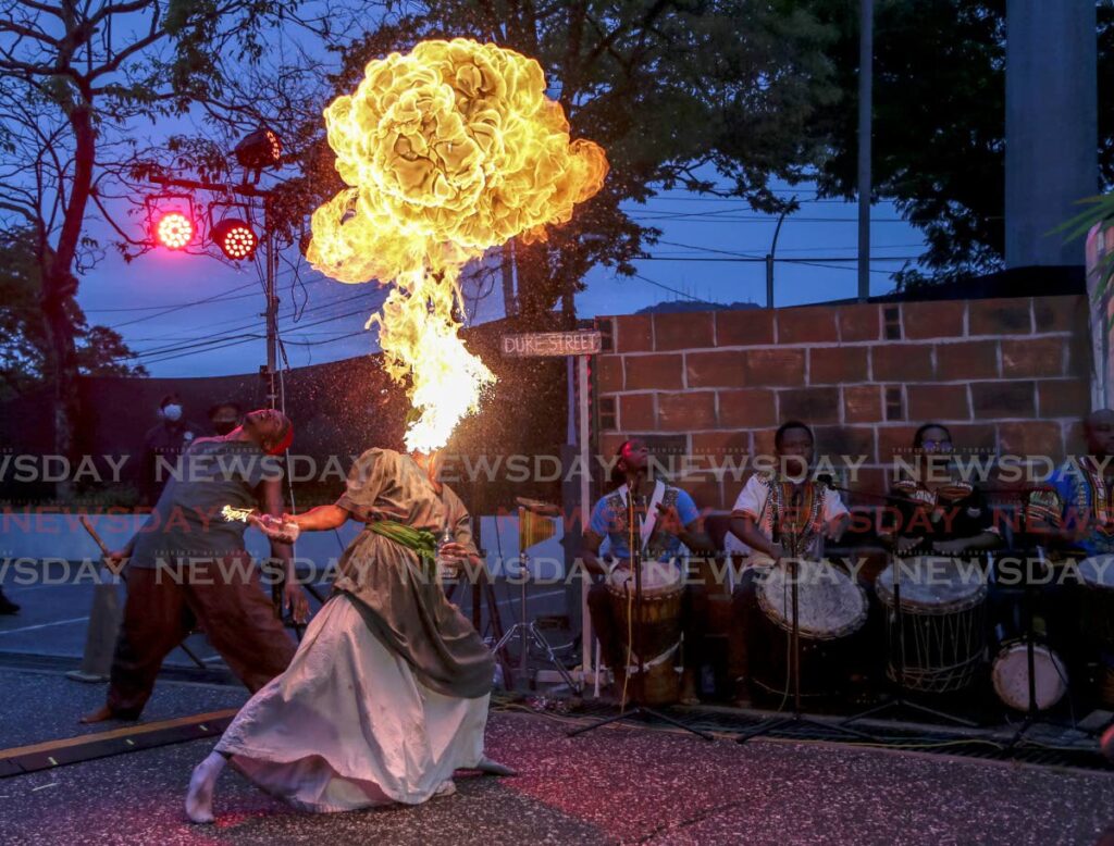A performer blows fire during the Canboulay riots re-enactment last Friday at the NAPA carpark in Port of Spain. PHOTO BY JEFF MAYERS  