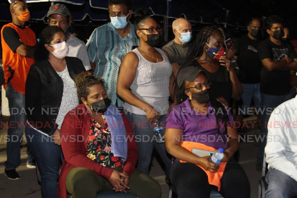 Heartbroken relatives and friends of divers Kazim Ali, Yusuf Henry, Rishi Nagassar and Fyzal Kurban sit in the carpark outside Heritage Petroleum in Pointe-a-Pierre on Sunday. after being told that the rescue operation has been turned into a recovery operation. - Photo by 
 Marvin Hamilton