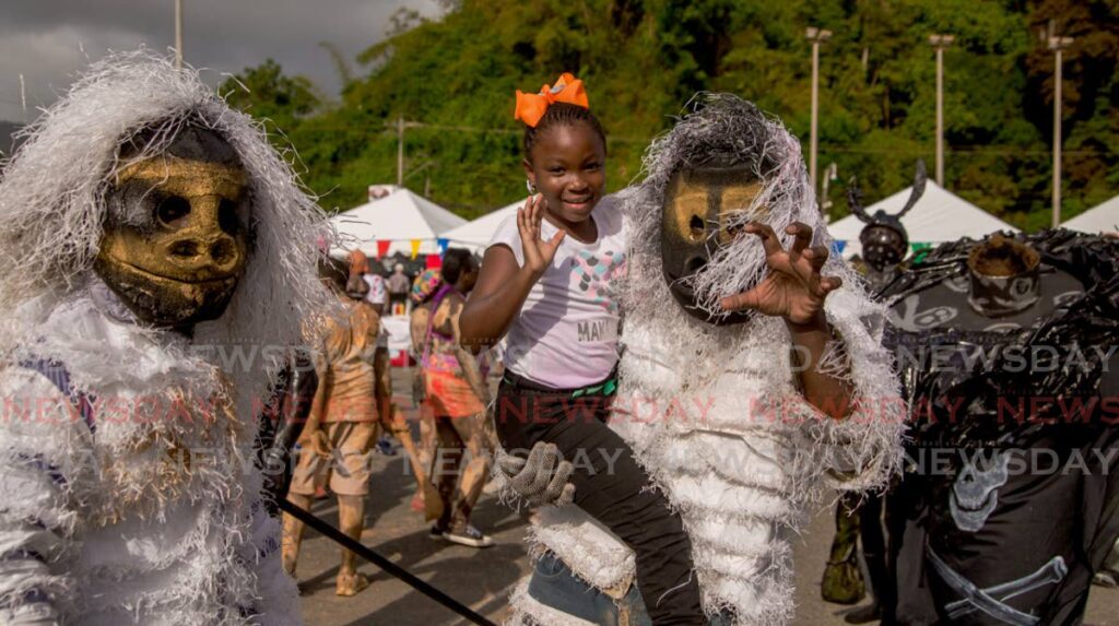 A youngster showed no fear for these traditional Carnival characters at the launch of Windward Carnival 2020 in Roxborough. FILE PHOTO  