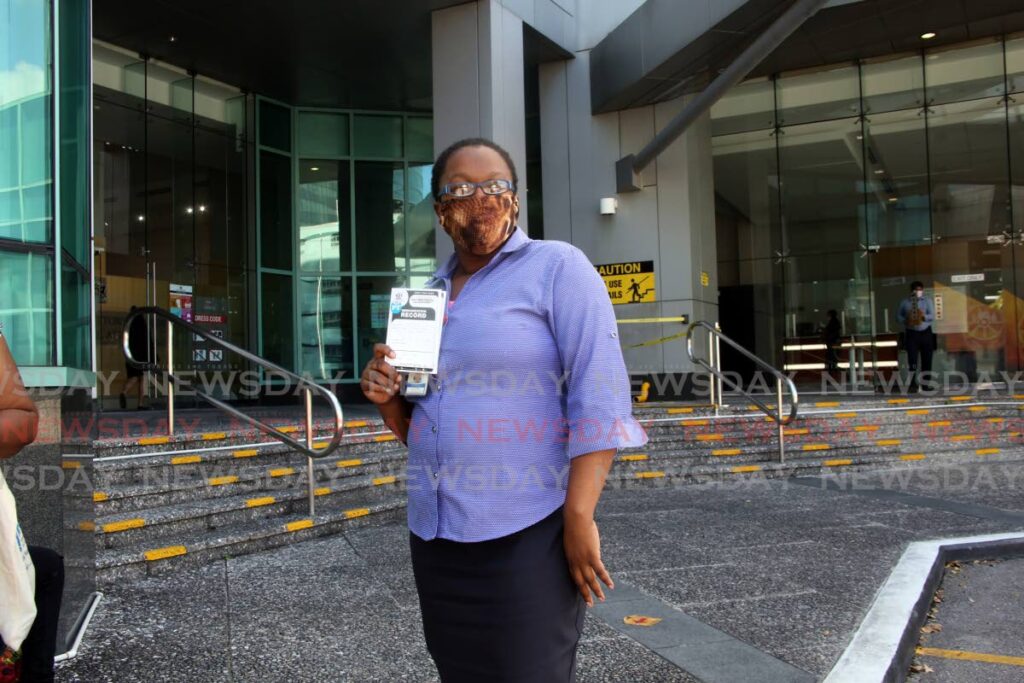 Public servant Anissa Williams holds her vaccination card after receiving a covid19 vaccine at the Ministry of the Attorney General and Legal Affairs, Government Campus, Port of Spain in January. All public servants are to return to work on Monday. - FILE PHOTO/SUREASH CHOLAI