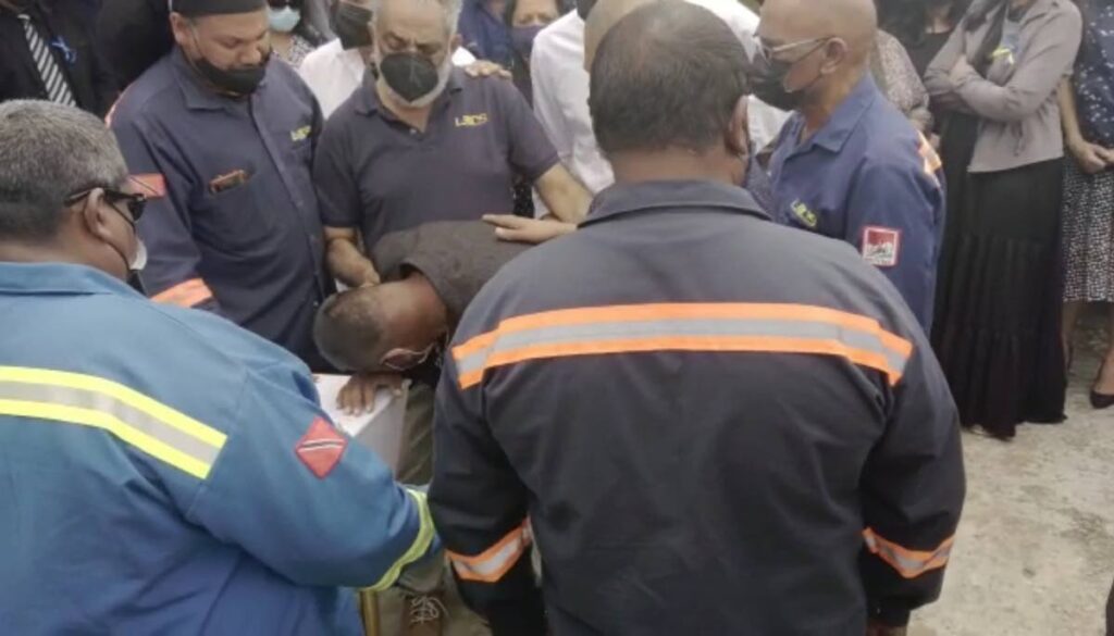 In this file photo, Christopher Boodram, the lone survivor of the Paria diving disaster, caressed the casket of Kazim Ali Jr during a memorial for his friend at LMCS Ltd, Marabella.