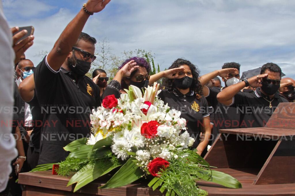 FAREWELL: Fyzal Kurban's family salute his closed casket at the cremation at the Mosquito Creek in La Romaine on Monday. PHOTO BY MARVIN HAMILTON - 