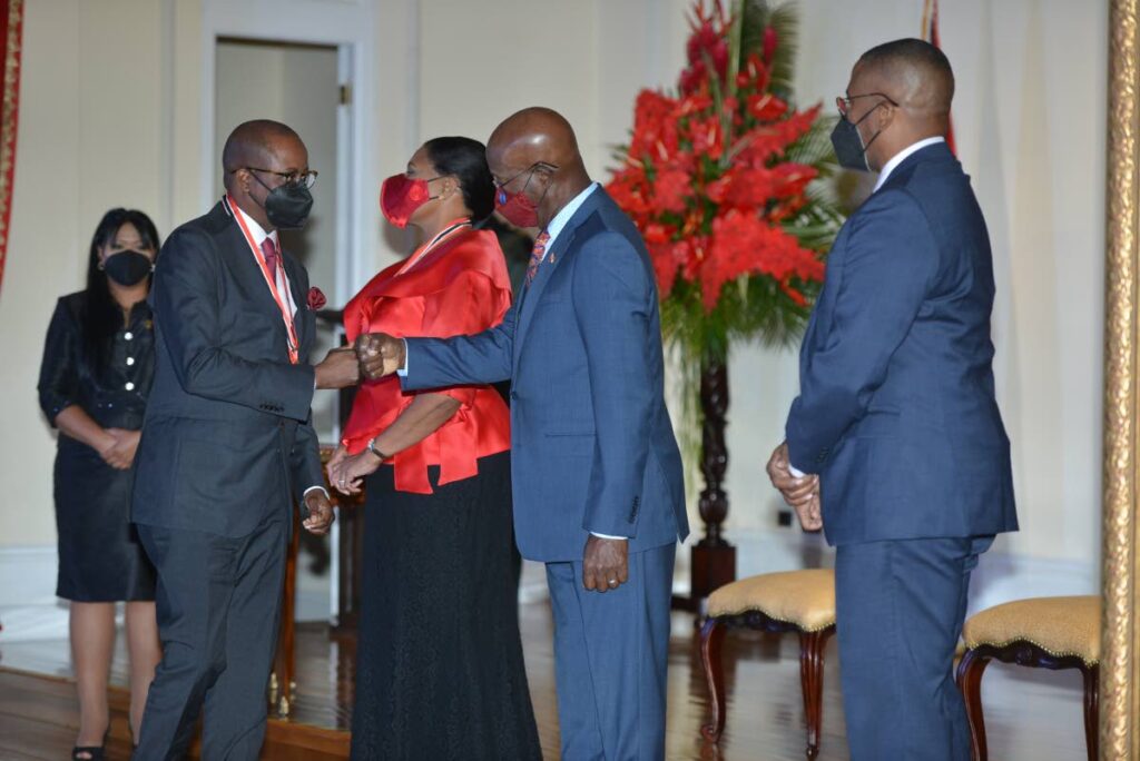 Dr Wayne Frederick, left, is congratulated by Prime Minister Dr Keith Rowley after receiving the Order of the Republic of TT from President Paula-Mae Weekes, centre,  as Chief Justice Ivor Archie looks on at a ceremony at President's House on Monday. - MEDIA POOL PHOTOGRAPER