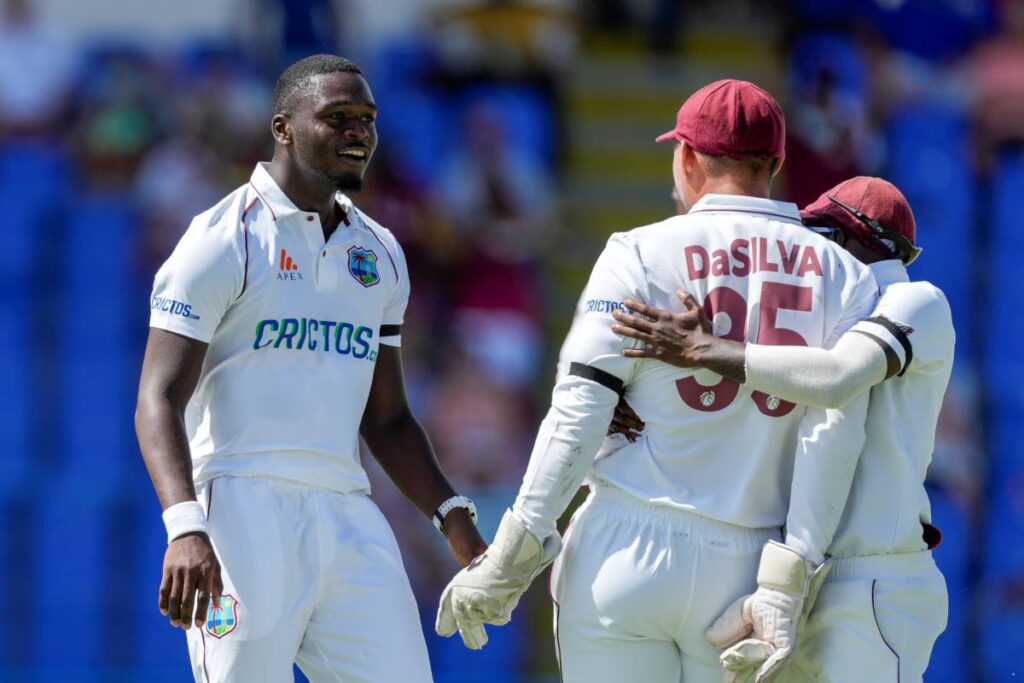 West Indies bowler Jayden Seales, left, celebrates a wicket with wicketkeeper Joshua Da Silva, centre, and another teammate on  day one of their first Test match vs England at the Sir Vivian Richards Cricket Ground in North Sound, Antigua, Tuesday. - AP