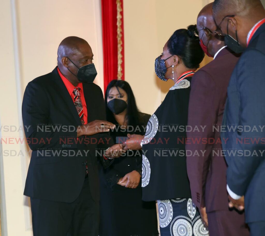 President Paula-Mae Weekes, centre, presents the Hummingbird Silver medal to Darryl Phillips,left, who received the award on behalf of his uncle and legendary Trinidad and Tobago goalkeeper Lincoln 'Tiger' Phillips. - SUREASH CHOLAI