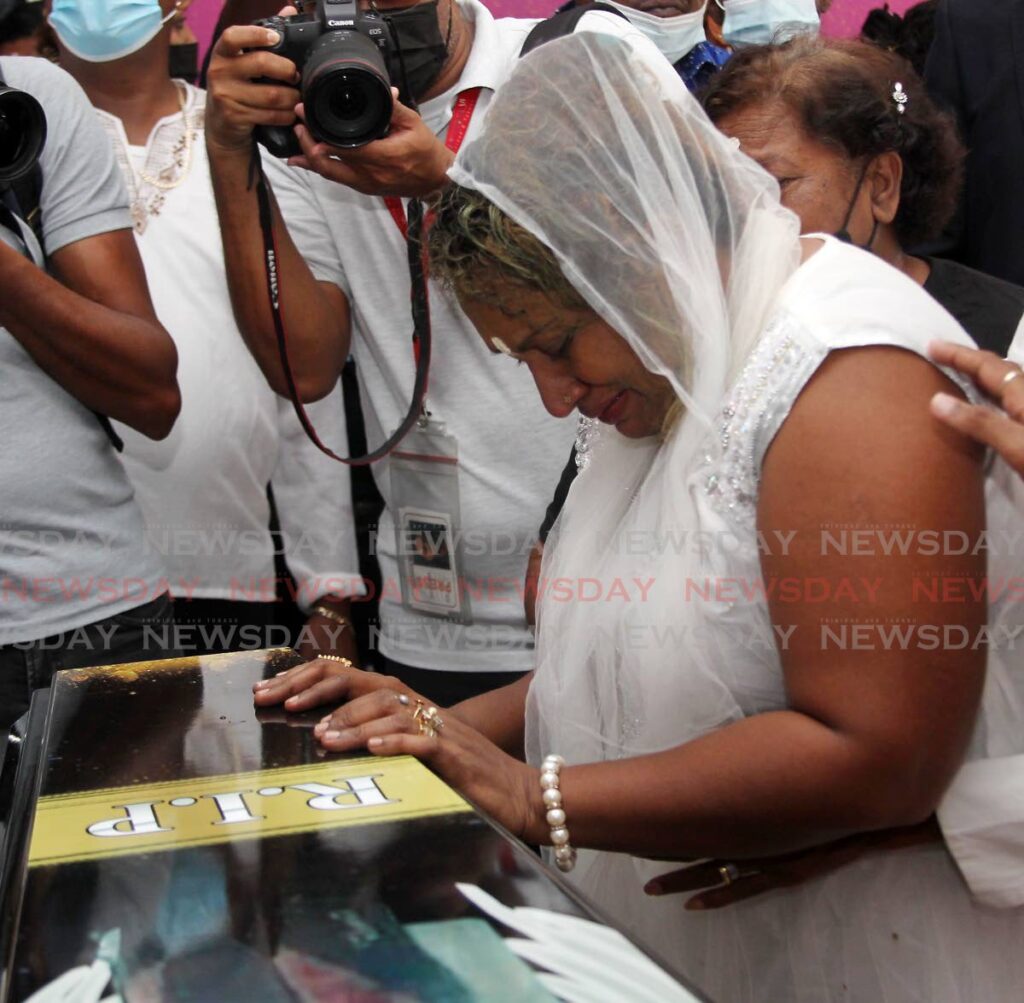Vanessa Kussie, wife of Rishi Nagassar, weeps over his casket at his funeral at , Richmond Stret, Perseverance village, Couva on Thursday.  - Angelo Marcelle