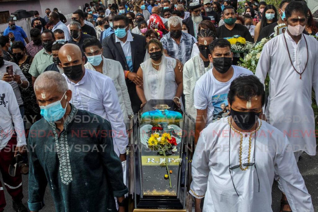 FINAL JOURNEY:
Vanessa Kussie, centre, during the funeral procession for her husband Rishi Nagassar in Couva on Thursday. Nagassar was one of four divers who drowned while doing maintenance work on Paria installations in the sea two weeks ago.

 - Angelo Marcelle