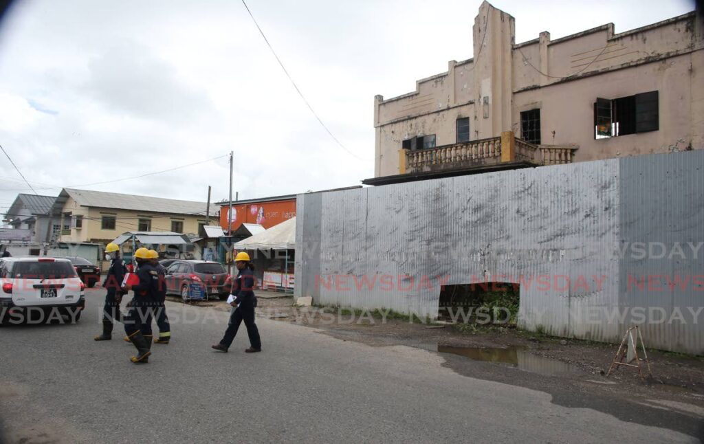 Fire officers leaving the scene of a fire that gutted a building that once housed a cinema called Venus along the La Romaine main road. The fire happened on Thursday night. - Lincoln Holder