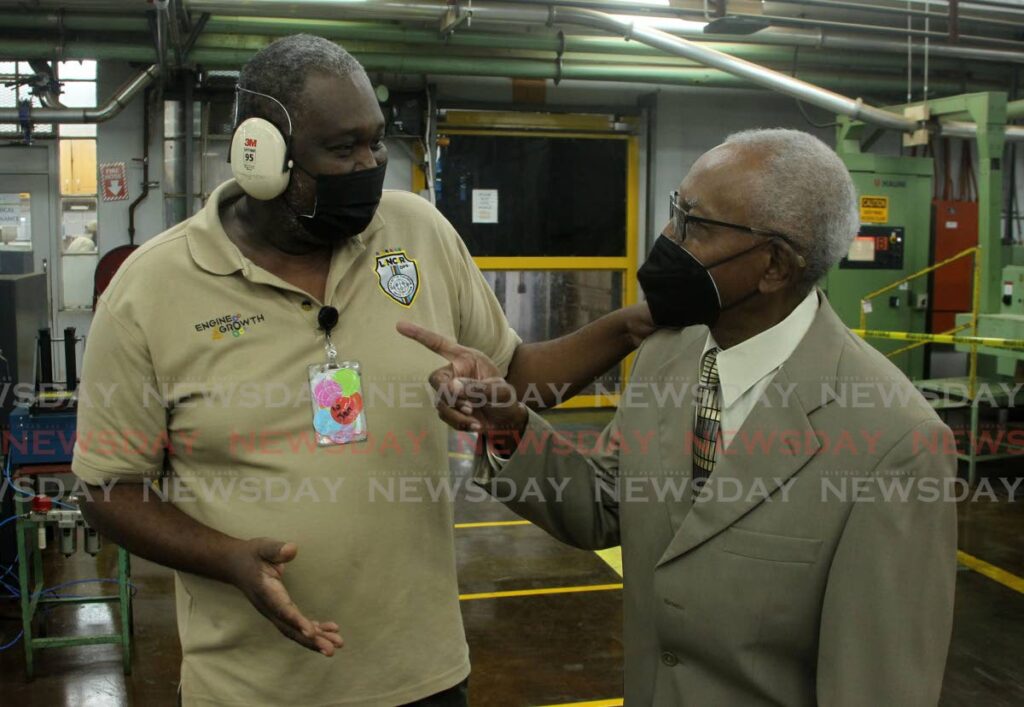 Witco chairman Anthony Phillip and machinery operator David Forte chat during the recommissioning of the upgraded factory in Champs Fleurs on March 11. - ROGER JACOB