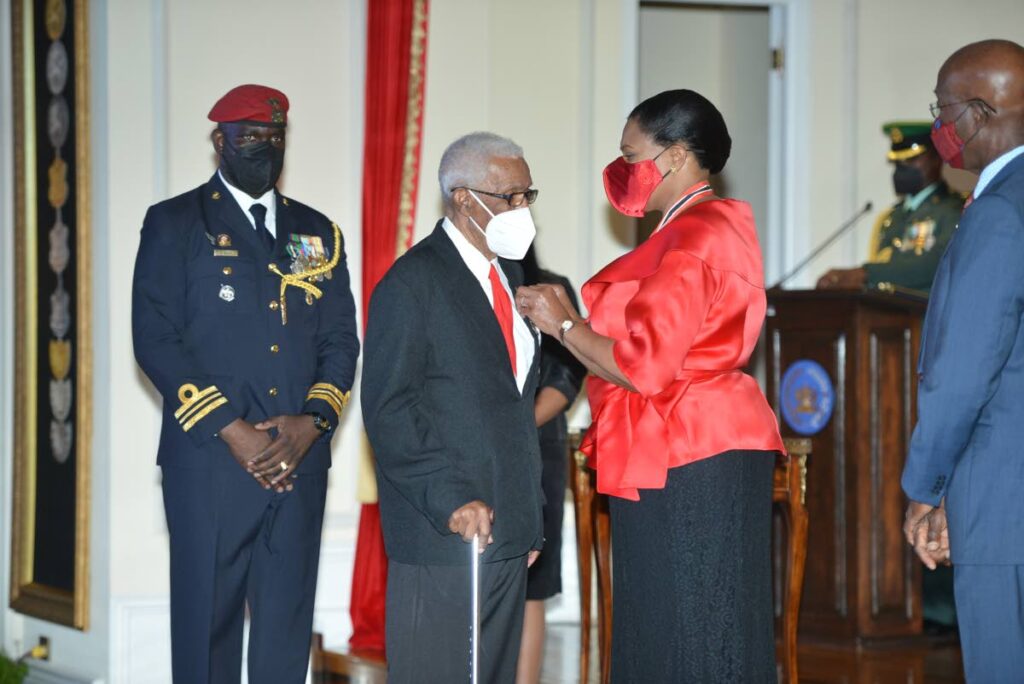 Ex-national football coach Edgar Vidale, second from left, receives the Chaconia Medal Silver from President Paula-Mae Weekes as Prime Minister Dr Keith Rowley, right, looks on, at the National Awards 2020, President's House, Port of Spain on Monday.  - Pool Photographer