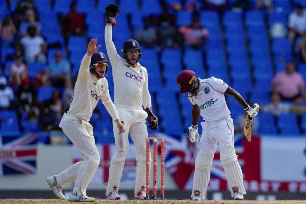 England’s Ollie Pope, left, and wicket keeper Ben Foakes celebrate the dismissal of West Indies’ Jermaine Blackwood during day five of their first Test match at the Sir Vivian Richards Cricket Ground in North Sound, Antigua, on Saturday. (AP Photo) - 