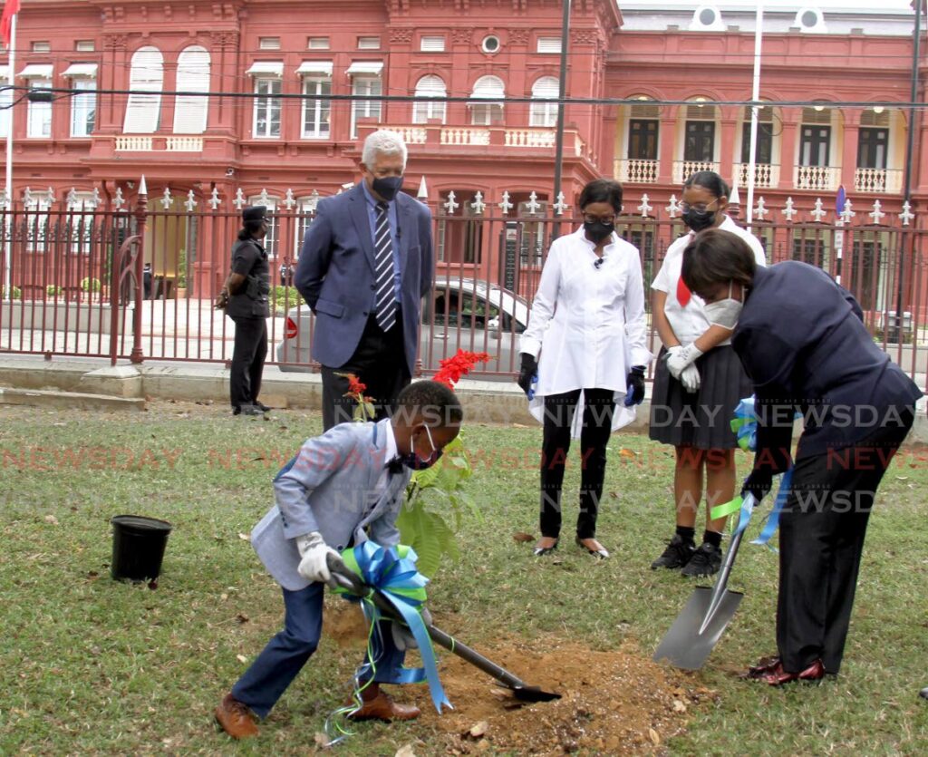 HARD AT WORK: Tobago schoolboy and planter Jhaylen Edwards, seven, and Speaker Bridgid Annisette-George plant a double chaconia at Woodford Square in Port of Spain on Monday to commemorate Commonwealth Day. Also in photo are, from left, PoS Mayor Joel Martinez, Senate President Christine Kangaloo and young planter Jahlene Forbes.  - Ayanna Kinsale