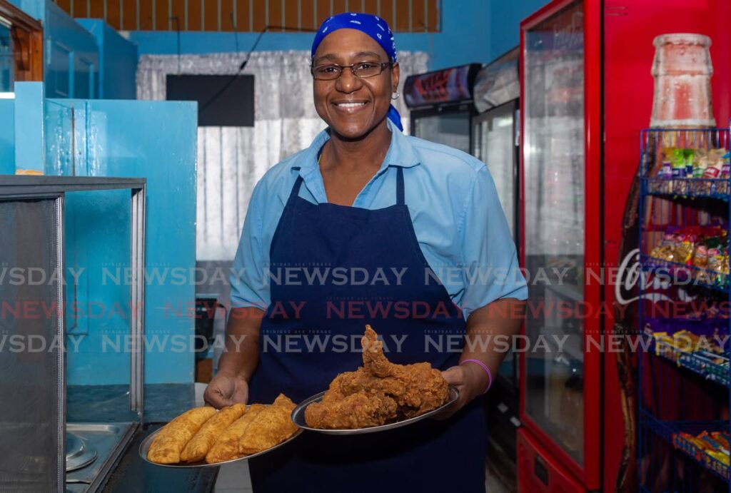 Antonia Roberts, owner of Bon Mange Ltd, shows some of her fried chicken and pies for sale at Eteck Mall, Scarborough.  - David Reid