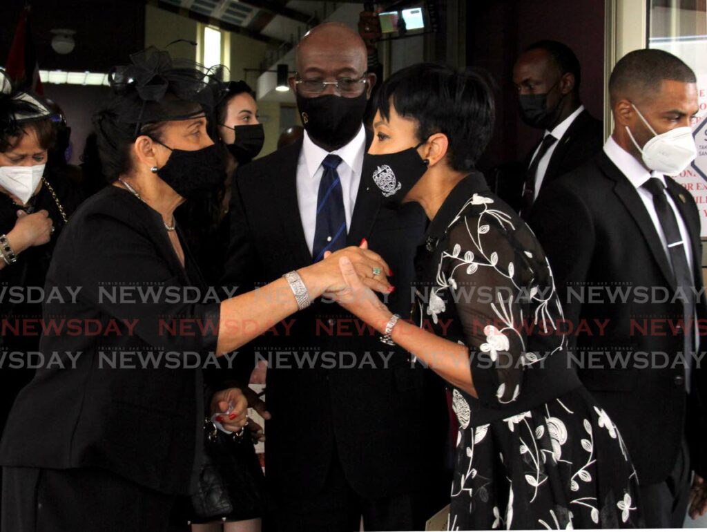 Jan Ryan, wife of Professor Selwyn Ryan, left, is consoled by Sharon Rowley, wife of Prime Minister Keith Rowley during Ryan's funeral at the St. Finbar's Roman Catholic Church, Morne Coco Road, Diego Martin. Looking on is Prime Minister Keith Rowley. Photo by Ayanna Kisnale