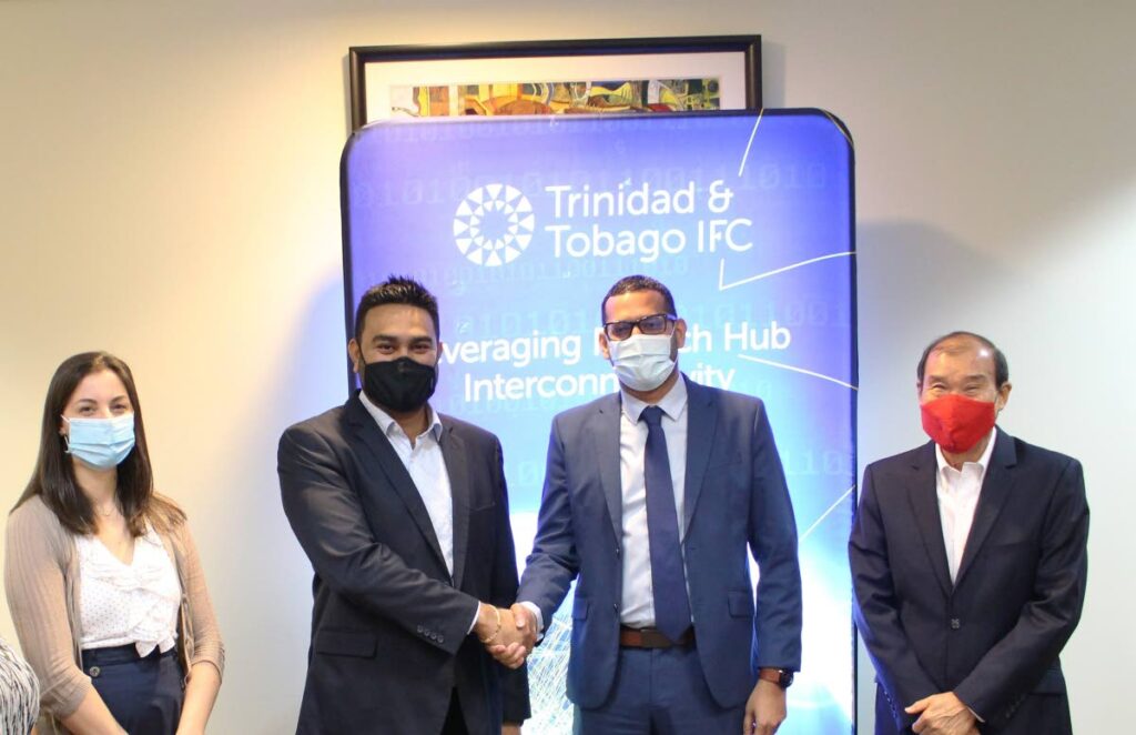 Jayesh Kasim, co-founder of Valenta Caribbean Ltd shakes hands with John Outridge, second from right,  CEO of the TT International Financial Centre (TTIFC) while the centre’s chairman Richard Young and Valenta’s head of marketing Valerie Chhokar look on, following the signing of a lease agreement at the TTIFC’s incubation hub on March 17. PHOTO COURTESY TTIFC - 