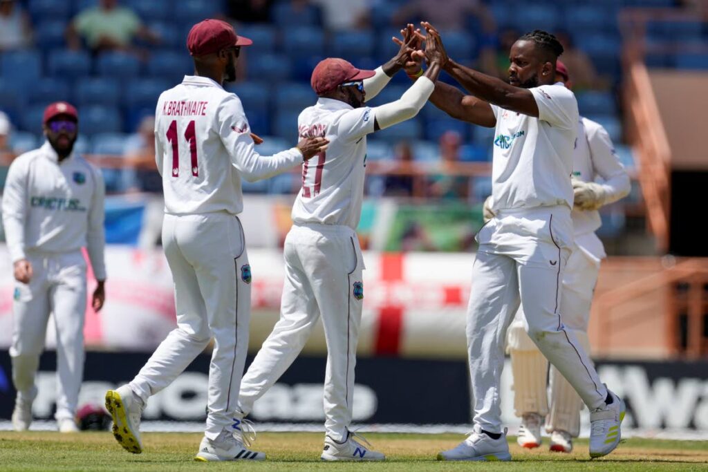 West Indies' Kyle Mayers, right, celebrates with teammates Jermaine Blackwood and Kraigg Brathwaite the dismissal of England's Zak Crawley during day one of their third Test match at the National Cricket Stadium in St George's, Grenada, on Thursday. (AP Photo) 