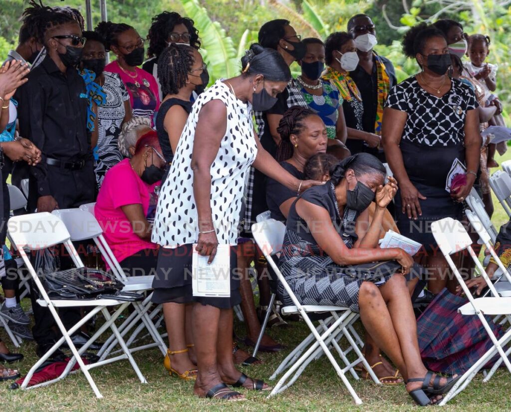 Sharon Cunningham, right, sister of deceased Tobago-born calypsonian and songwriter, Sherwin Cunningham, grieves at her brother's funeral held at Elizabeth Dennis Baird Recreation Grounds, Mason Hall, Tobago last Thursday. - 