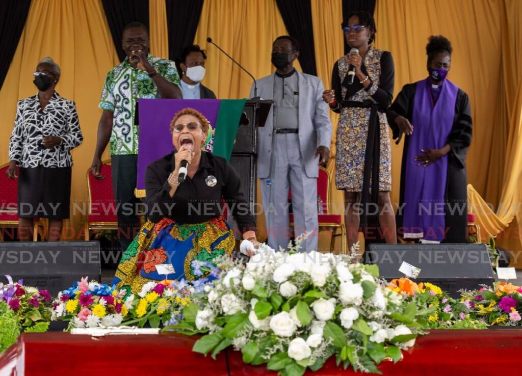  Jay-Anne Baptiste Campbell, centre, the niece of deceased Tobago born calypsonian and songwriter, Sherwin Cunningham performs at Cunningham's funeral. 