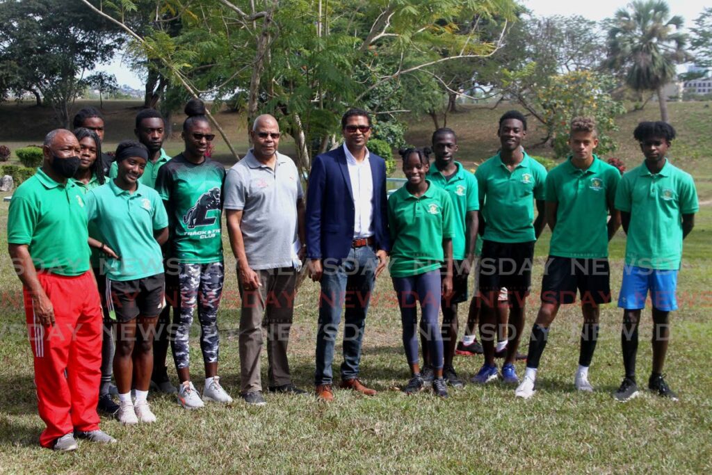 Carifta Games 2022 patron Richard Pandohie ( blue blazer) and NAAA president George Comissiong, fourth from left, stand alongside members of the TT team, on Tuesday, at the Botanical Gardens, Queen’s Park Savannah Port of Spain. At left is Cougars Track and Field coach Kelvin Nancoo.  - ROGER JACOB