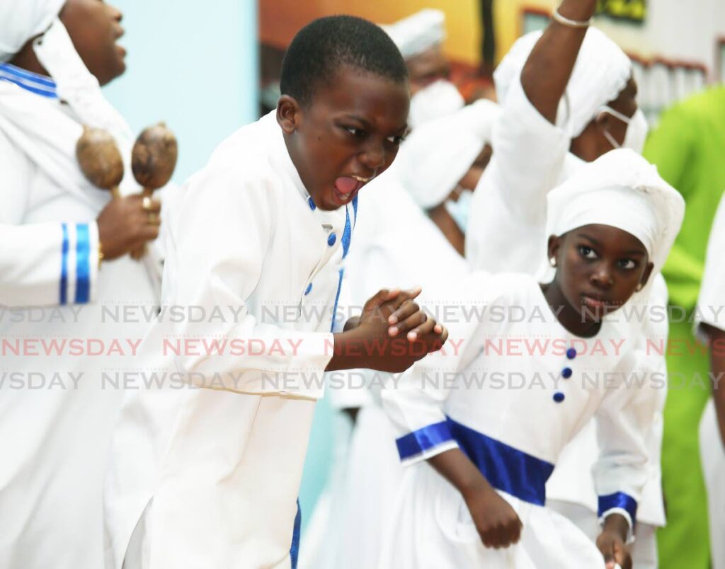 SHOUT TO THE HILLS: Lemuel Mottley, 8, and his sister Chauntelle, 6, sing songs of praise during Spiritual Shouter Baptist Liberation Day celebrations at the Chaguanas Borough Corporation auditorium on Wednesday. 
PHOTO BY LINCOLN HOLDER - LINCOLN HOLDER