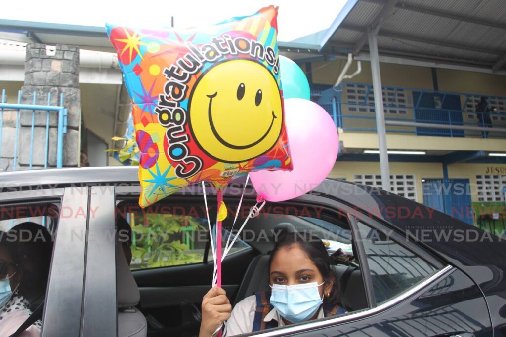 A student leaves happy with balloons after writing the SEA exams at Grant Memorial Presbyterian School  in San Fernando on Thursday.  Photo by Marvin Hamilton