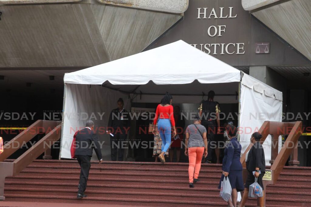 In this March 2020 file photo, security officers at the Hall of Justice, Port of Spain screen members of the public, attorneys and Judiciary in keeping with its covid19 health policy, before courts were closed and trials were held virtually. In-person trials are due to resume on Monday. - 