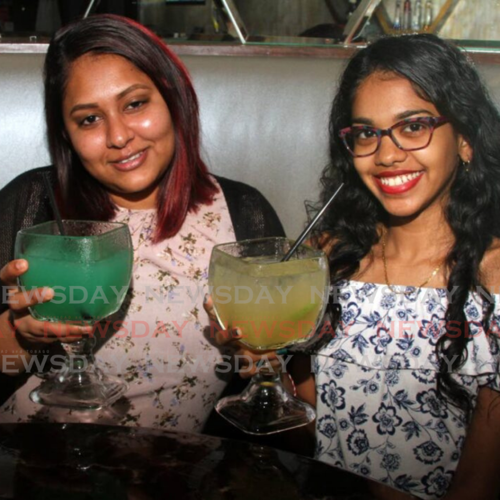 Jamie Edoo and Christina Hosein toast a Shamrock Punch and the Luck of the Irish drink at Buzz Bar, C3 Centre, San Fernando on March 17. As of April 4, the vaccinated and unvaccinated can mix at venues like bars when safe zones comes to an end. Photo by Angelo Marcelle