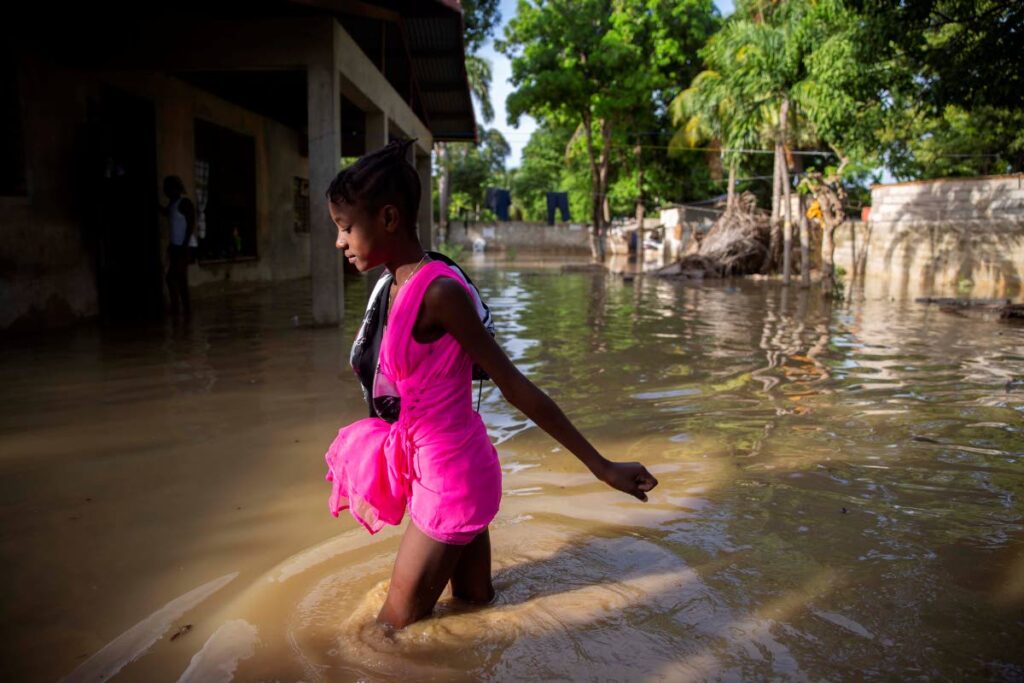 In this August 24, 2020 file photo, a girl wades towards her flooded home the day after the passing of Tropical Storm Laura in Port-au-Prince, Haiti. The storm battered the Dominican Republic and Haiti during its passage through the Caribbean.  (AP Photo)