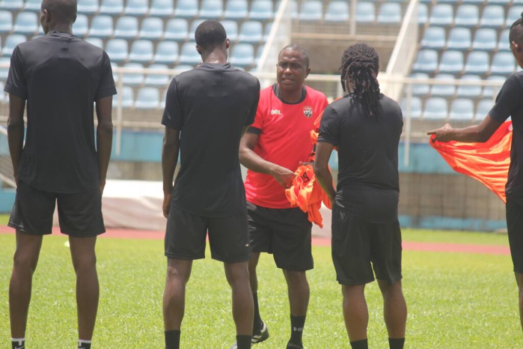 TT senior men’s head coach Angus Eve (in red) speaks with players during a training session, at the Ato Boldon Stadium, in Couva.   (TTFA File photo)