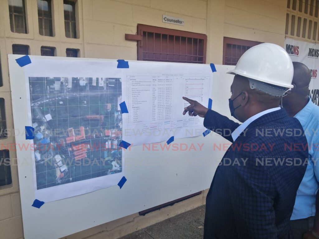 In this April file photo, Minister of Youth Development and National Service Foster Cummings looks at the plans for the refurbishment of the St Michael's Home for Boys. Next to him is contractor Stephen Small. Photo by Jensen La Vende