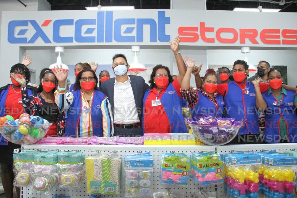 CEO of Excellent Stores Alex Siu Chong, centre, takes a photo with staff during the opening of their latest branch at Brentwood Mall, Chaguanas, on Saturday. - AYANNA KINSALE