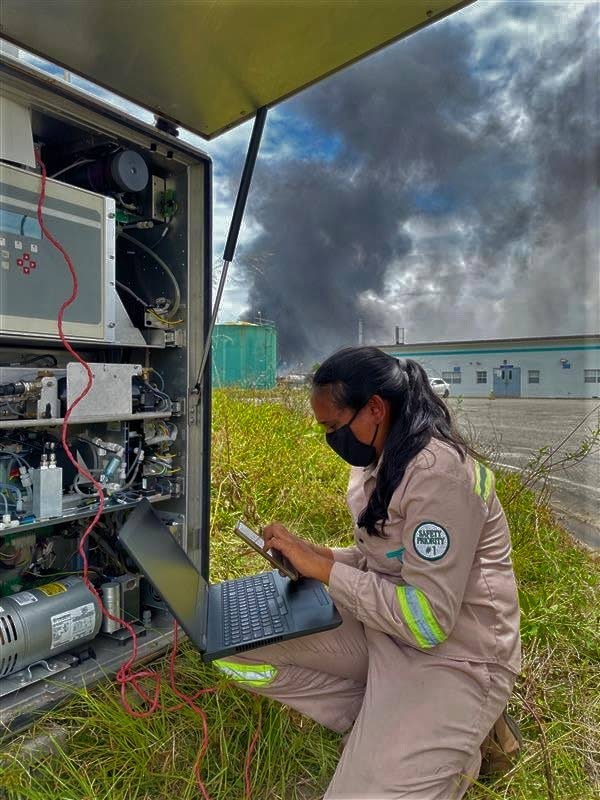 TESTS: With thick, noxious smoke billowing from fires in the nearby Beetham landfill, an Environmental Management Authority (EMA) technician tests the air quality on Thursday. This photo was posted to the EMA's Facebook page.  - EMA