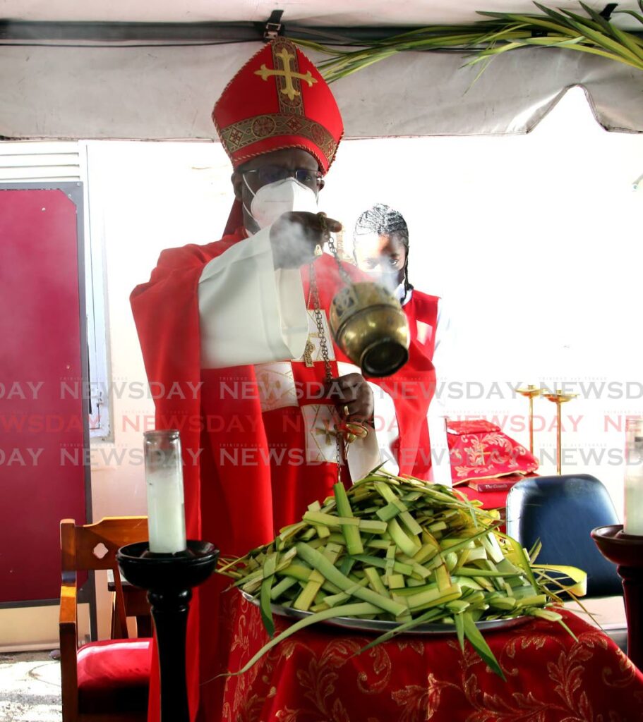BLESSING: Anglican Bishop Claude Berkeley blesses palm leaves with holy incense during Palm Sunday Mass under a tent in the car park of the Holy Trinity Cathedral. PHOTO BY SUREASH CHOLAI - 