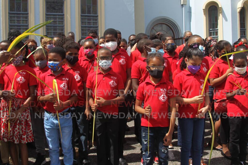 Young people, some with blessed Palm leaves, gather outside the Our Lady of Perpetual Help Church before the start of the Mass. PHOTO BY MARVIN HAMILTON - 