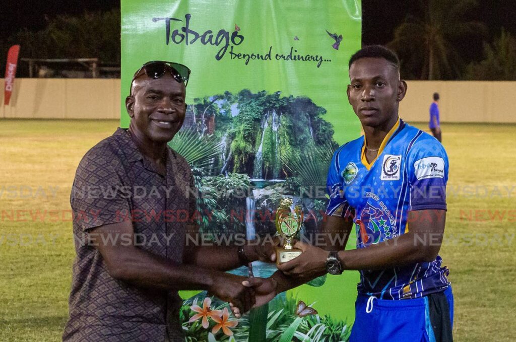 Jaron Alfred of the Rain Buccoo Reef Cricket Team (right) collects the Man of the Match trophy during the Chief Secretary Bago T10 Cricket Blast, at the Cyd Gray Sporting Complex, Roxborough, on Sunday. - David Reid