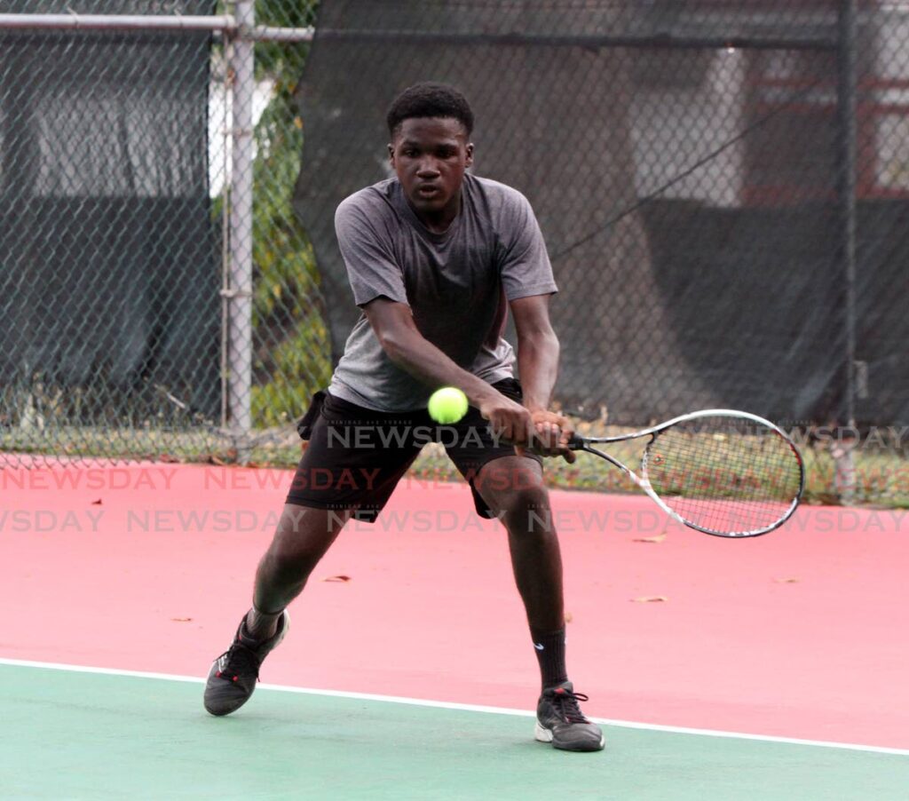 Shae Millington makes an attempt to return a serve, during his match against Tim Pasea, in the Boys 18-and-Under Division 1 singles, quarterfinal, in the RBC Junior Tennis Tournament at Country Club, Maraval on Tuesday. - Angelo Marcelle