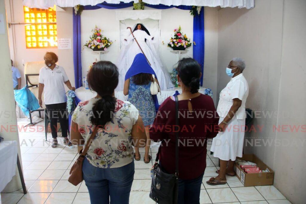 Devotees pay homage to the La Divina Pastora / Siparee Mai statue at the La Divina Pastora RC Church in Siparia on Thursday. - Photo by Lincoln Holder