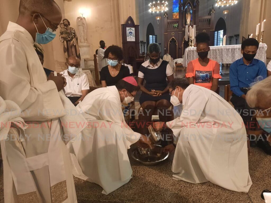 Archbishop Jason Gordon washes the feet of parishioners at the Cathedral of the Immaculate Conception in Port of Spain on Holy Thursday. - Paula Lindo