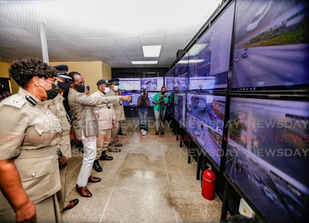 National Security Minister Fitzgerald Hinds, centre, points to a screen at the launch of the police operational centre at the Barataria/El Socorro police station on Thursday. Photo by Jeff Mayers