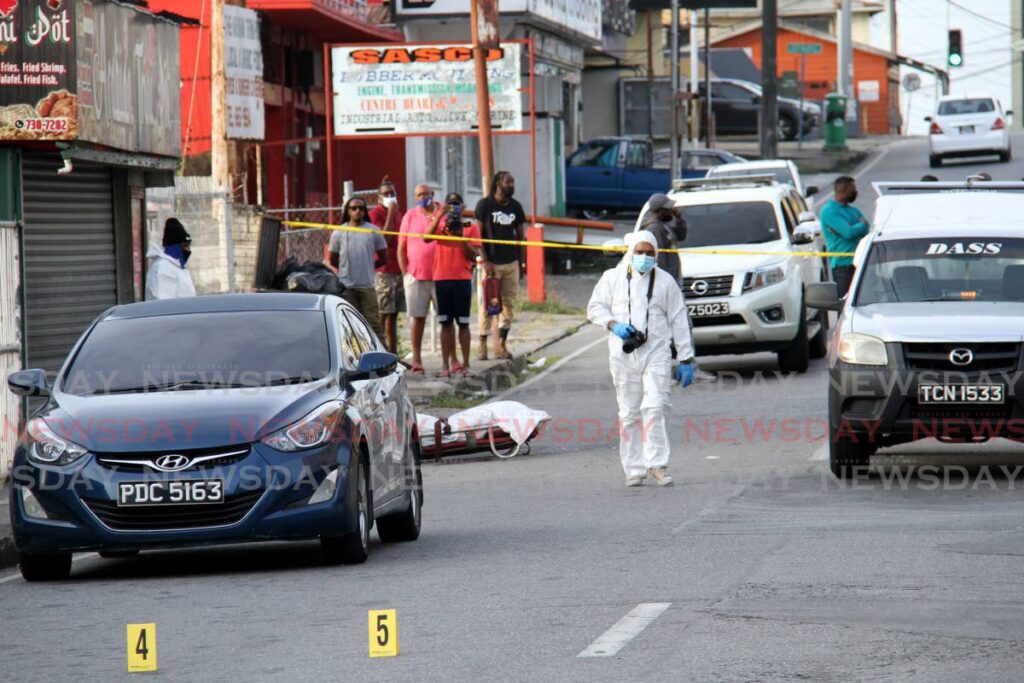 CRIME SCENE: In this file photo police at the crime scene after Junior Chase was shot dead on Good Friday in San Fernando. PHOTO BY AYANNA KINSALE - 